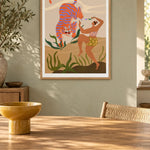 Dance With Me by Arty Guava – orange tiger with violet stripes beside a dancing woman and green leaves. Oak-framed print above a dining table in a sunlit sage room.