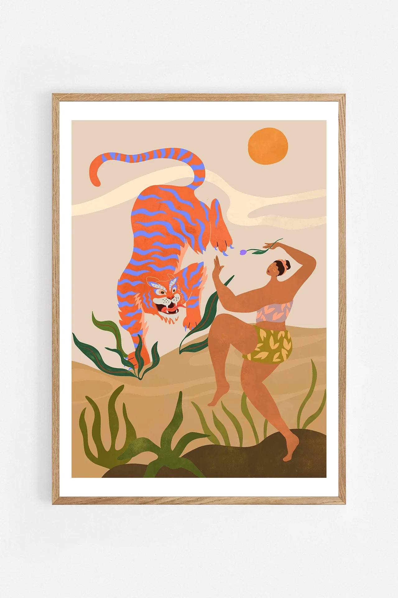Dance With Me by Arty Guava – orange tiger with violet stripes beside a dancing woman and green leaves. Art print shown in a natural oak frame on a white wall.